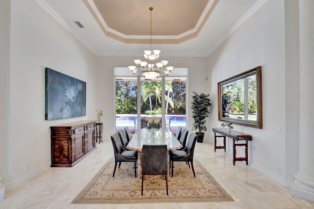 dining space with a notable chandelier, crown molding, and a tray ceiling