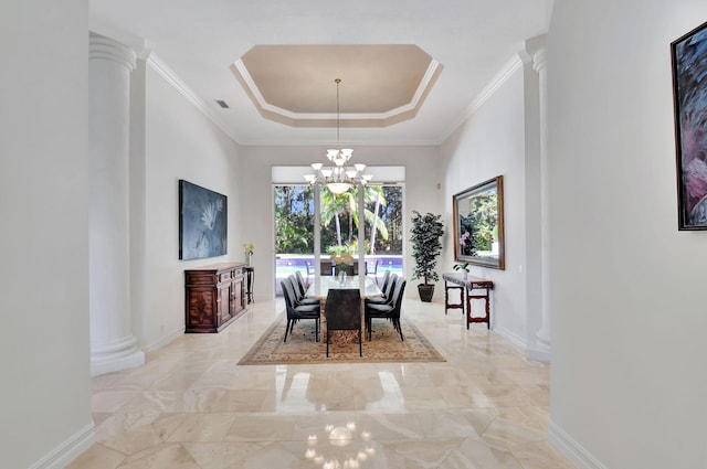 dining room with a chandelier, a tray ceiling, ornate columns, and crown molding