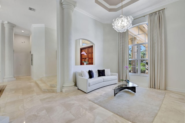 living room featuring a chandelier, decorative columns, and ornamental molding