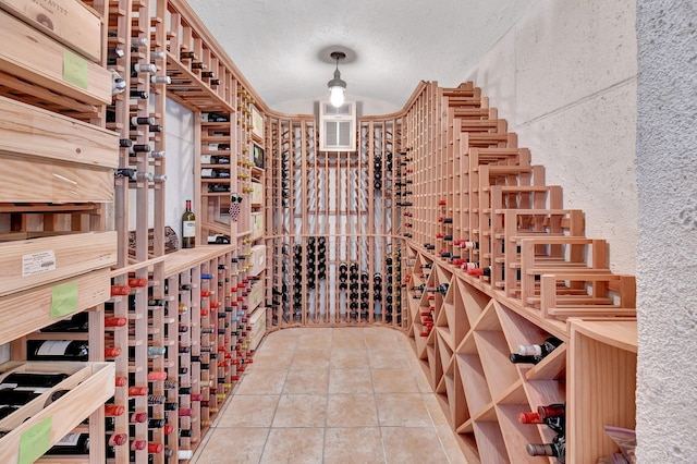 wine room with tile patterned flooring and a textured ceiling