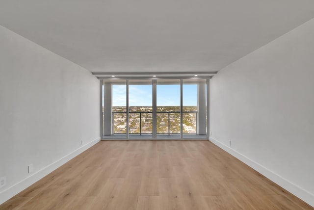 unfurnished room featuring light hardwood / wood-style floors and floor to ceiling windows