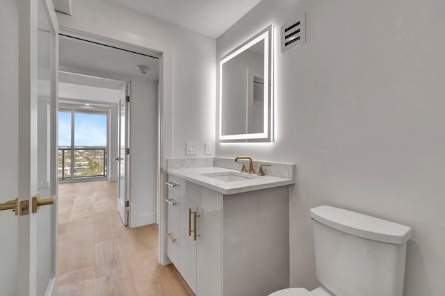 bathroom featuring hardwood / wood-style floors, vanity, and toilet