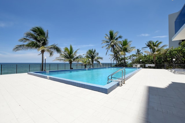 view of swimming pool featuring a patio area and a water view