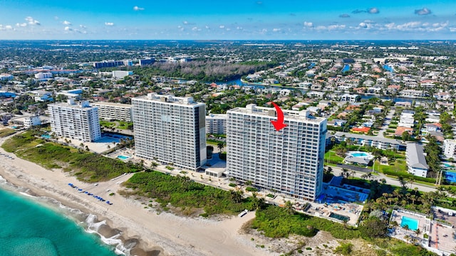 birds eye view of property featuring a water view and a beach view