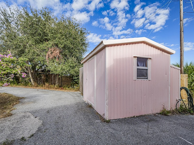 view of outdoor structure with an outbuilding and fence