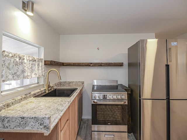 kitchen featuring stainless steel appliances, dark wood-type flooring, a sink, and light stone countertops