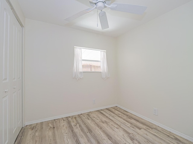 empty room featuring light wood-style floors, baseboards, and a ceiling fan