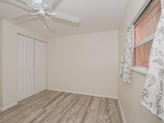 unfurnished bedroom with light wood finished floors, ceiling fan, baseboards, and a closet