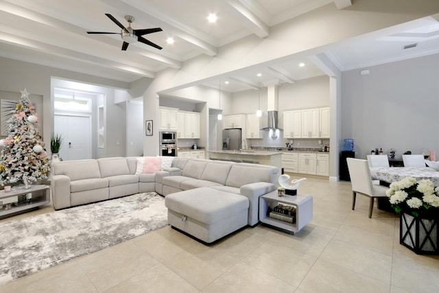 tiled living room featuring a high ceiling, sink, crown molding, ceiling fan, and beam ceiling