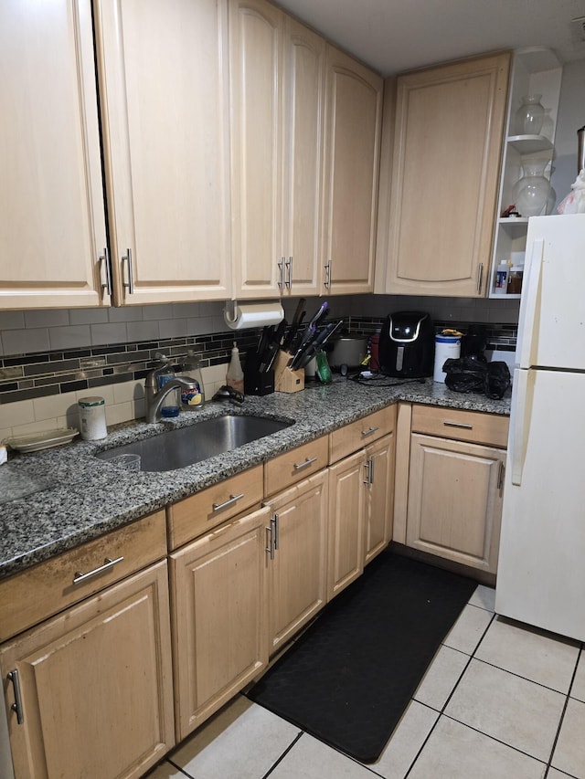 kitchen with decorative backsplash, sink, light brown cabinets, light tile patterned floors, and white fridge