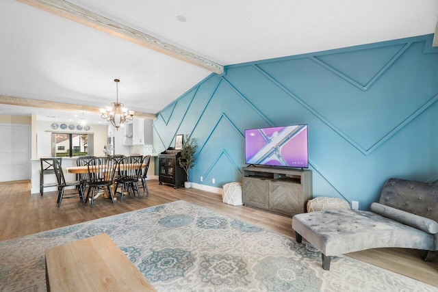 living room featuring lofted ceiling with beams, a notable chandelier, and hardwood / wood-style flooring