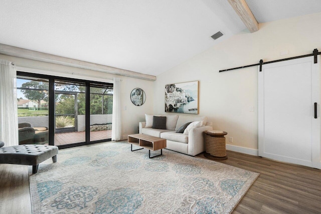 living room featuring vaulted ceiling with beams, a barn door, and wood-type flooring