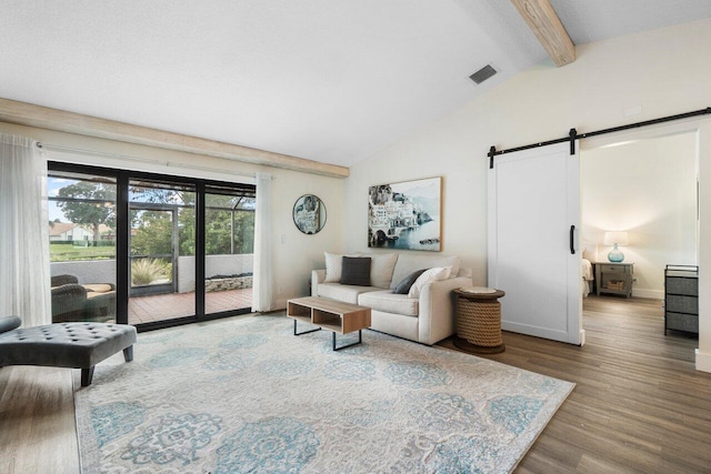 living room featuring hardwood / wood-style floors, a barn door, and lofted ceiling with beams