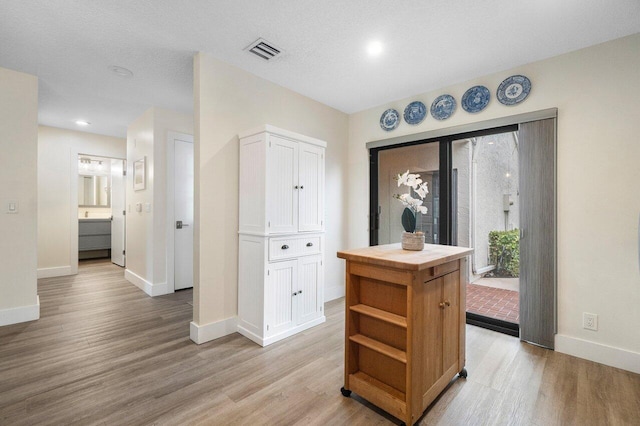 interior space with light hardwood / wood-style floors and a textured ceiling