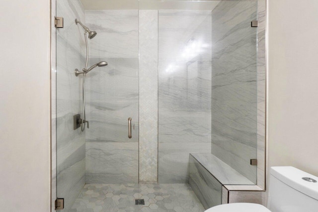 bathroom with toilet and an enclosed shower