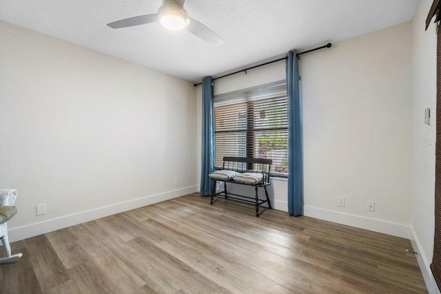 spare room with wood-type flooring, a textured ceiling, and ceiling fan