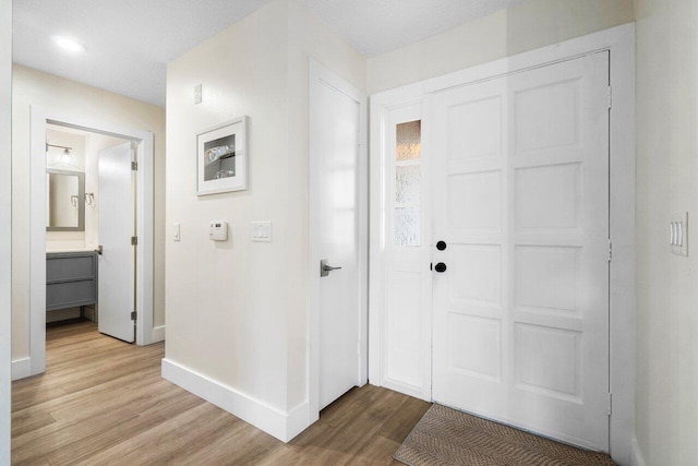 foyer entrance with light wood-type flooring and a textured ceiling