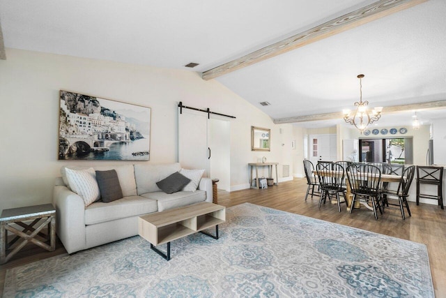 living room with a barn door, lofted ceiling with beams, wood-type flooring, and an inviting chandelier