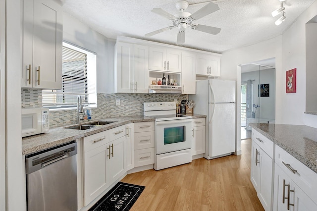 kitchen featuring a textured ceiling, white appliances, white cabinetry, and sink