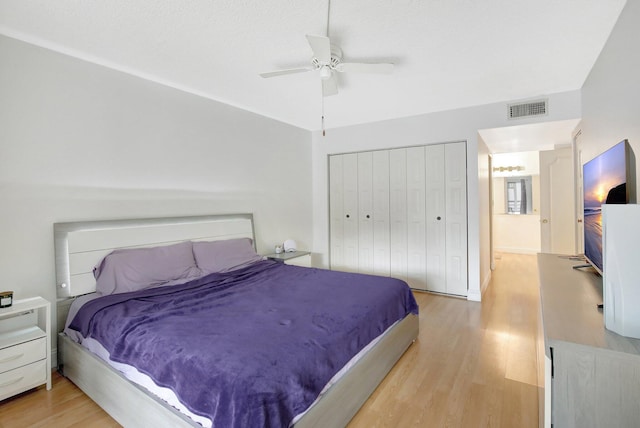 bedroom with ceiling fan, a closet, and hardwood / wood-style flooring