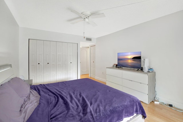 bedroom with ceiling fan, a closet, a textured ceiling, and light wood-type flooring