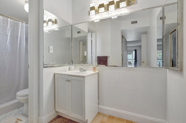 bathroom featuring hardwood / wood-style flooring, toilet, vanity, and walk in shower