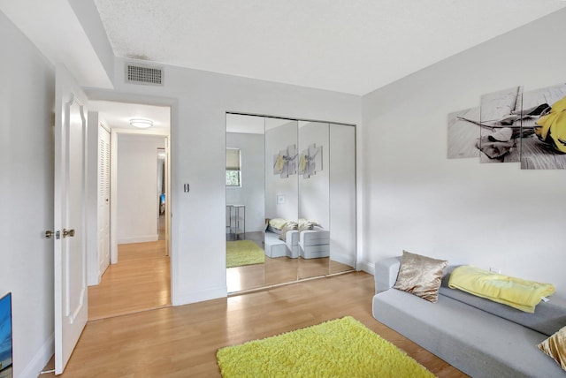 living area featuring a textured ceiling and light hardwood / wood-style flooring