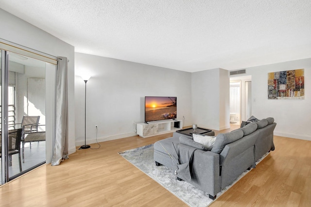 living room with light wood-type flooring and a textured ceiling