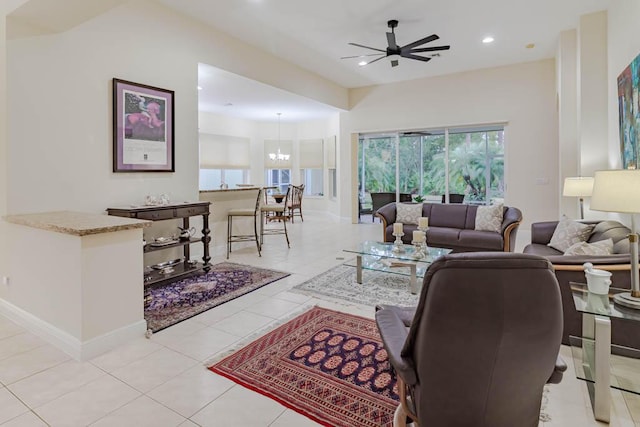 living room with light tile patterned floors, baseboards, recessed lighting, and ceiling fan with notable chandelier