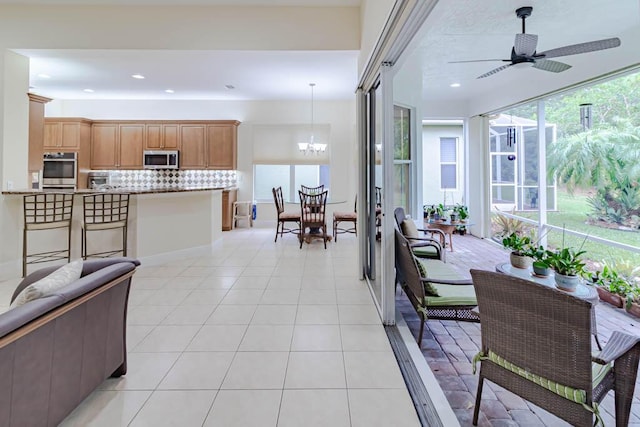 living room with light tile patterned flooring, recessed lighting, and ceiling fan with notable chandelier