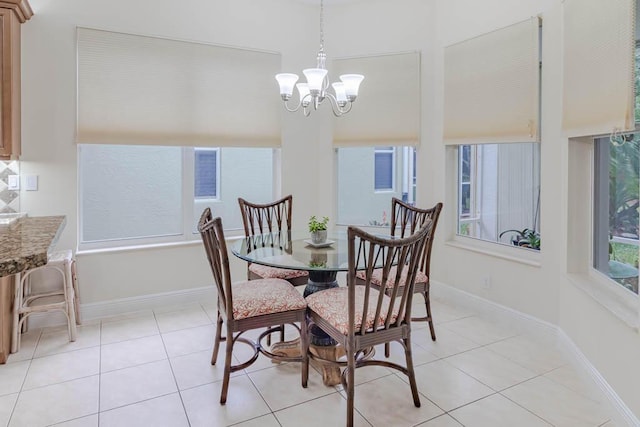 dining room with light tile patterned floors, baseboards, and a chandelier