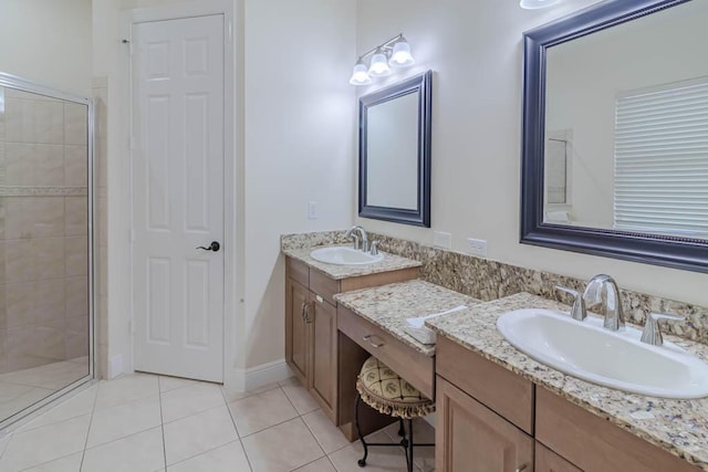 full bath with vanity, baseboards, a stall shower, and tile patterned flooring