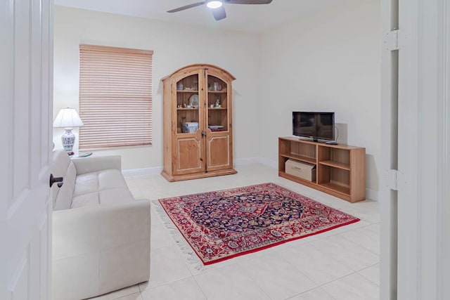 interior space featuring baseboards, a ceiling fan, and tile patterned flooring