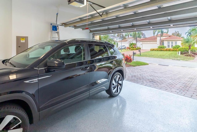 garage featuring electric panel, a garage door opener, and a residential view