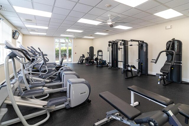 workout area featuring visible vents, a paneled ceiling, baseboards, and ceiling fan