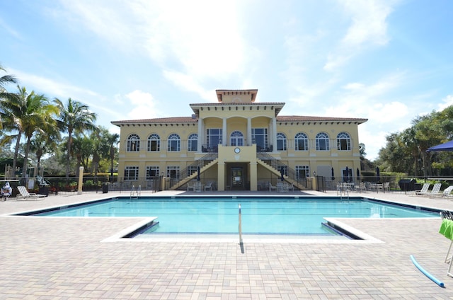 community pool with a patio and fence