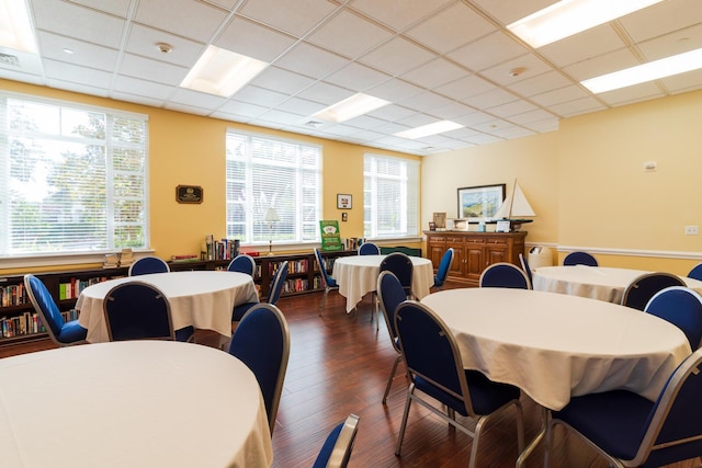 dining area with a drop ceiling, a healthy amount of sunlight, dark wood-style floors, and visible vents