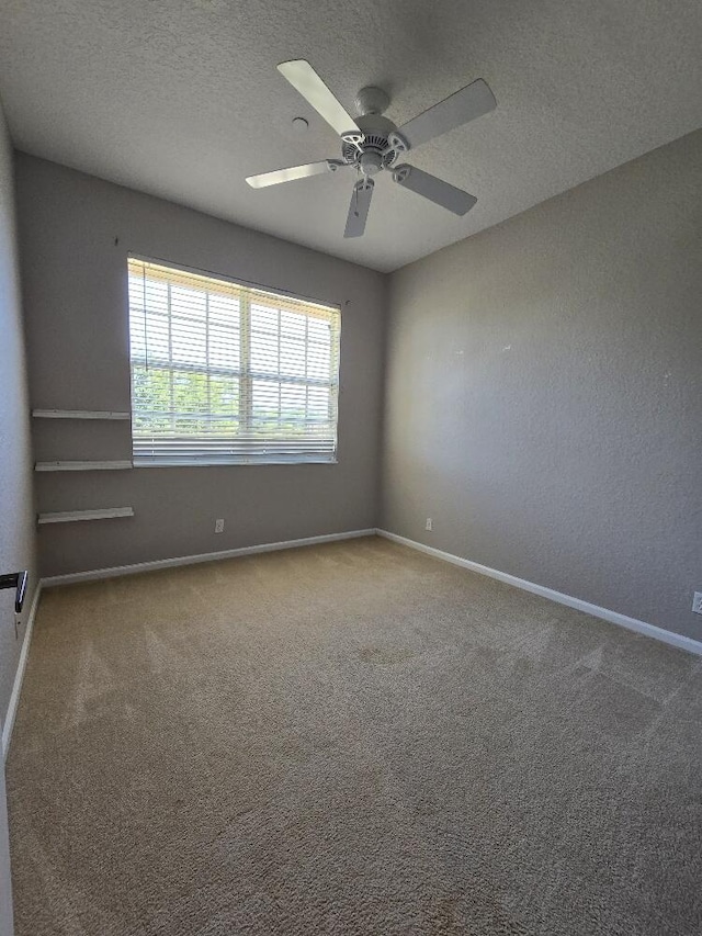 carpeted empty room featuring ceiling fan and a textured ceiling