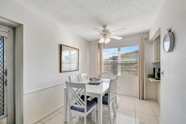 tiled dining room with ceiling fan and a textured ceiling