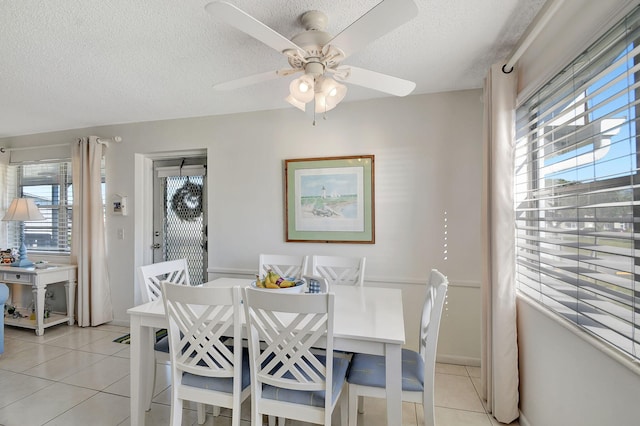 tiled dining room featuring ceiling fan, plenty of natural light, and a textured ceiling