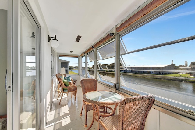 sunroom / solarium featuring a water view