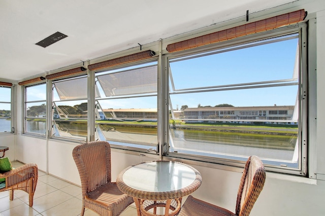 sunroom / solarium featuring a water view