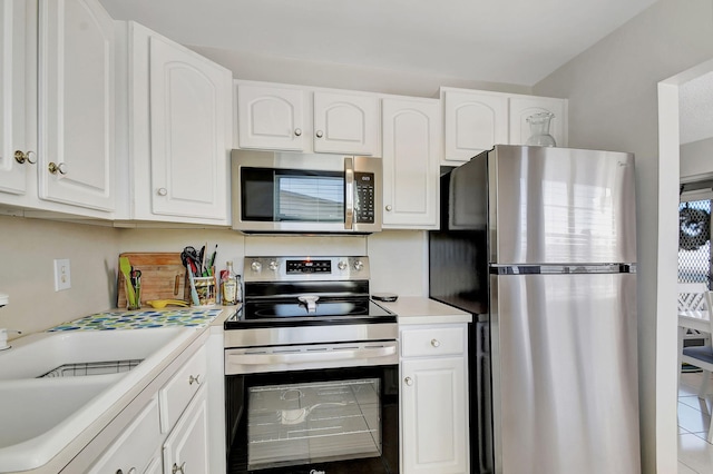 kitchen featuring tile patterned floors, white cabinetry, and appliances with stainless steel finishes