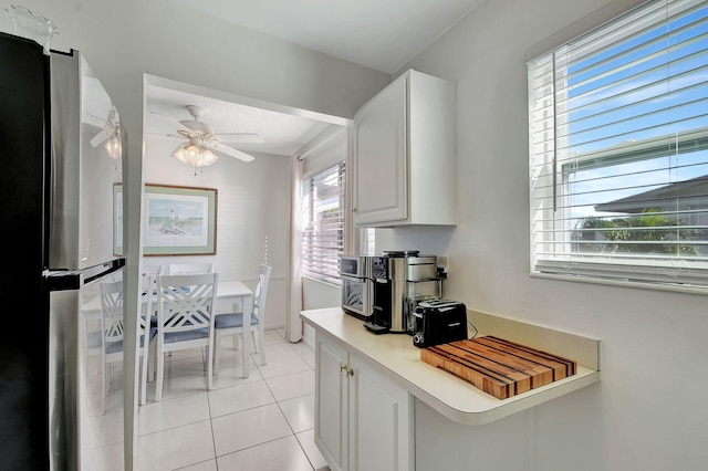 kitchen with white cabinetry, a wealth of natural light, and stainless steel fridge