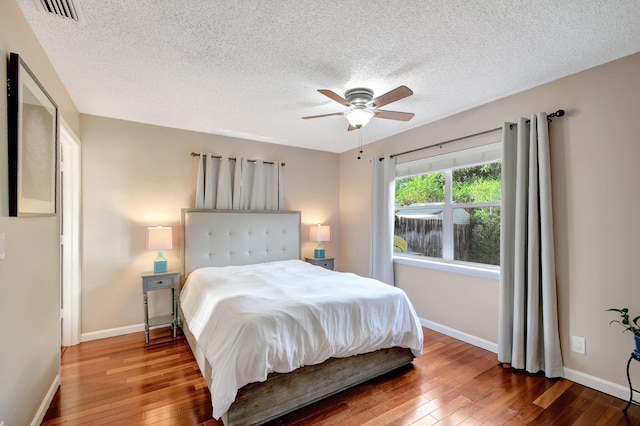 bedroom featuring a textured ceiling, hardwood / wood-style flooring, and ceiling fan