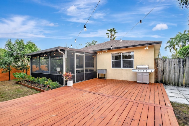 wooden deck with area for grilling and a sunroom