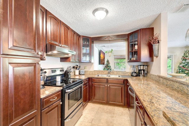 kitchen with sink, light stone countertops, and stainless steel appliances