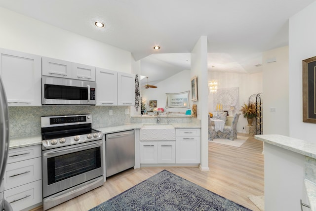 kitchen featuring appliances with stainless steel finishes, tasteful backsplash, sink, light hardwood / wood-style flooring, and white cabinetry