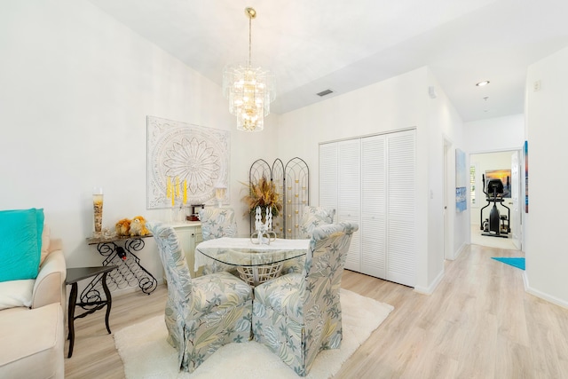 dining room featuring a notable chandelier and light wood-type flooring