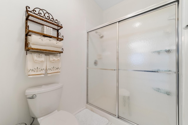 bathroom with an enclosed shower and toilet